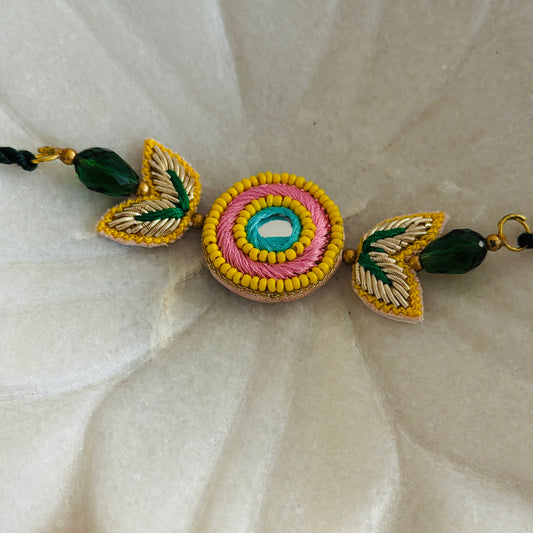 Handcrafted Circle Motif Rakhi – Green Thread with Leaf Accents